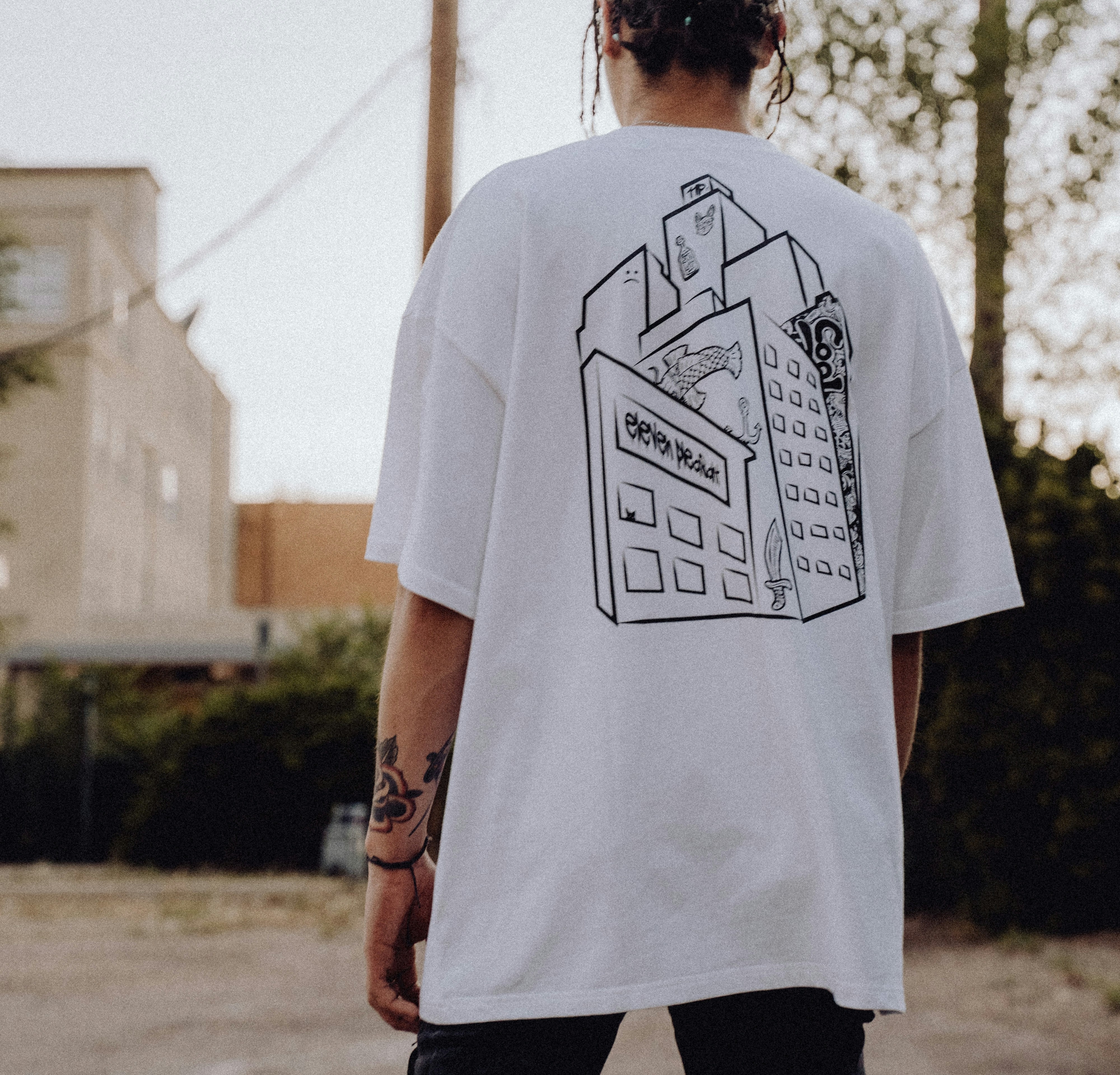 Person wearing branded artist merchandise t-shirt with tattoo artwork design
